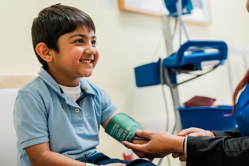 A child getting his blood pressure checked by a nurse