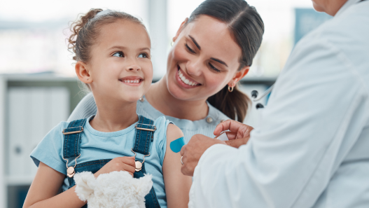 Child smiling with mother getting a bandaid from a doctor