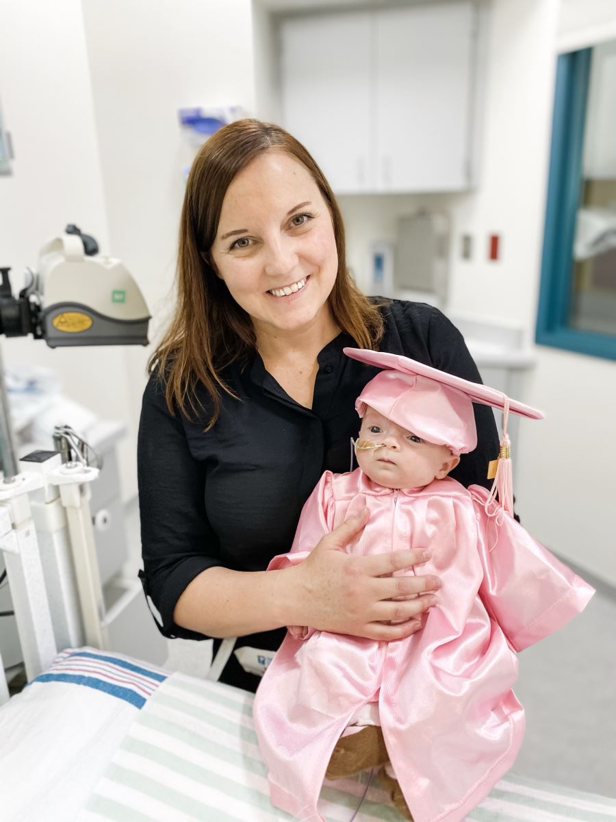 Emmie and mom Chantelle smile as Emmie graduates from the NICU