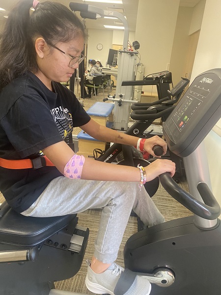 Faith rides a bicycle as part of her recovery