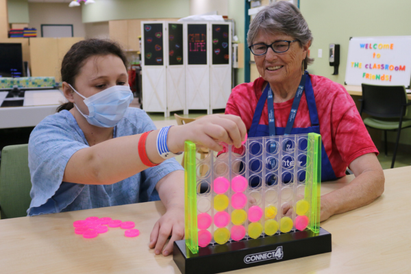 Valley Children's volunteer Barbara plays a game with a patient