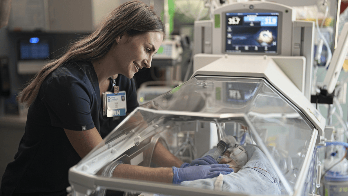 A NICU nurse attends to a baby