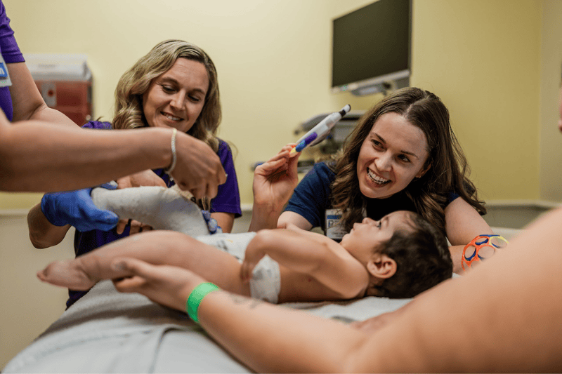 Dr. Jill Friebele and a child life specialist attend to a young patient