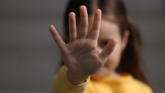 Young girl holds her hand out toward camera