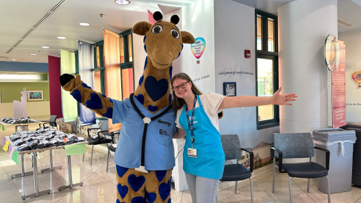 George the Giraffe standing with volunteer, Sophia
