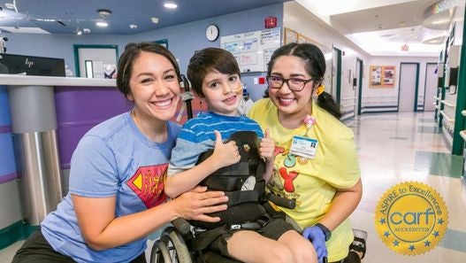 Two Valley Children's Employees posing with Valley Children's Patient