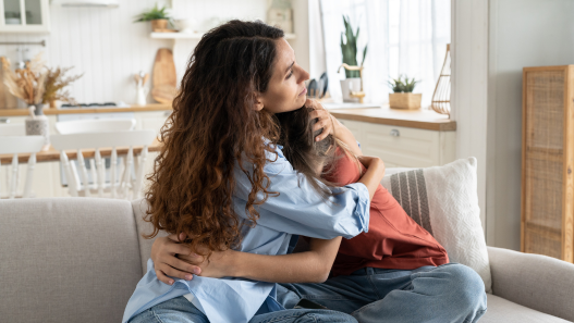 Mom and Daughter Hugging on Couch