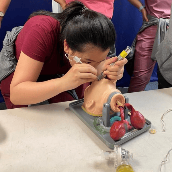 A pediatric resident practices intubation on a mannequin